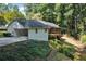 Exterior view of a home with a long driveway leading to a carport and a screened porch at 1590 Sunnybrook Farm Rd, Atlanta, GA 30350
