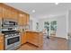 Well-lit kitchen boasts stainless steel appliances, tile floors and wood cabinets at 1590 Sunnybrook Farm Rd, Atlanta, GA 30350