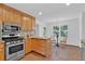 Bright kitchen features stainless steel appliances, granite countertops, and light wood cabinets at 1590 Sunnybrook Farm Rd, Atlanta, GA 30350
