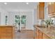 Kitchen featuring natural wood cabinetry, granite counters, and stainless dishwasher at 1590 Sunnybrook Farm Rd, Atlanta, GA 30350