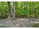 Stone patio featuring beautiful mature trees and wrought iron table and chairs at 1590 Sunnybrook Farm Rd, Atlanta, GA 30350