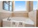 Relaxing bathroom with a soaking tub and stylish fixtures, framed by neutral-toned tiling at 3268 Shirecrest Ln, Dacula, GA 30019