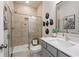 Bathroom featuring tile shower with glass door and modern vanity with art pieces and ample storage at 3268 Shirecrest Ln, Dacula, GA 30019