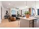 Open-concept design with stainless steel appliances and a view of the living room with fireplace and decor at 3268 Shirecrest Ln, Dacula, GA 30019