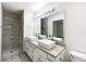 Modern bathroom featuring dual sinks, granite countertops, and a tiled shower at 7972 Woodlake Dr, Riverdale, GA 30274