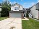 Charming two-story home featuring a gray garage door and well-maintained front yard at 7972 Woodlake Dr, Riverdale, GA 30274