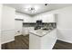 Well-lit kitchen featuring white cabinets, granite countertops, and stainless steel appliances at 7972 Woodlake Dr, Riverdale, GA 30274