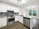 Bright kitchen with stainless appliances, granite counters, white cabinetry, and eat in kitchen at 7972 Woodlake Dr, Riverdale, GA 30274