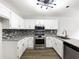 Updated kitchen features white cabinets, granite counters, and stainless steel appliances at 7972 Woodlake Dr, Riverdale, GA 30274