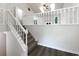 Bright staircase featuring white railings and wood flooring at 7972 Woodlake Dr, Riverdale, GA 30274