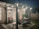 Cozy backyard patio area is equipped with outdoor seating, a fire pit, and string lights at night at 918 Harvest Brook Dr, Lawrenceville, GA 30043