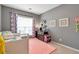 Comfortable bedroom with a bed, pink rug, and plenty of natural light at 918 Harvest Brook Dr, Lawrenceville, GA 30043