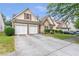 Home exterior with a two-car garage, well-kept lawn, and attractive landscaping in a residential neighborhood at 918 Harvest Brook Dr, Lawrenceville, GA 30043