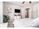 Bright bedroom with a queen bed, mounted tv, and open door to another room at 1875 Conners Ct, Lawrenceville, GA 30044