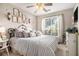 Inviting bedroom with neutral tones, featuring a ceiling fan, decorative pillows, and natural light at 1875 Conners Ct, Lawrenceville, GA 30044