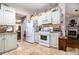 Well-equipped kitchen features tile backsplash, white appliances, and access to a dining area at 1875 Conners Ct, Lawrenceville, GA 30044