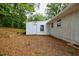 Spacious backyard featuring a white detached garage, nestled amongst mature trees at 766 Brian Ln, Forest Park, GA 30297