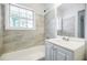Bathroom features a white vanity, bathtub and shower combination, and natural light at 766 Brian Ln, Forest Park, GA 30297