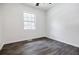 Bright bedroom features modern window, neutral paint, and dark wood-look floors at 766 Brian Ln, Forest Park, GA 30297