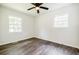 Well-lit bedroom offering vinyl floors, white walls, a ceiling fan, and two windows for natural light at 766 Brian Ln, Forest Park, GA 30297