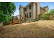 Backyard view with a wooden deck and stairs, surrounded by greenery and a wood privacy fence at 507 Mirramont Pl, Woodstock, GA 30189