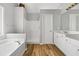 Bright bathroom featuring a soaking tub, walk-in shower, wood-look flooring, and a double vanity at 507 Mirramont Pl, Woodstock, GA 30189