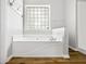 Bright bathroom featuring a soaking tub with tile surround and a window providing natural light at 507 Mirramont Pl, Woodstock, GA 30189