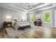 Bright bedroom featuring a tray ceiling, wood floors, neutral decor and lots of natural light at 507 Mirramont Pl, Woodstock, GA 30189
