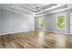 Spacious bedroom with a trey ceiling, wood floors, and windows providing an abundance of natural light at 507 Mirramont Pl, Woodstock, GA 30189