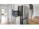 Kitchen area with stainless steel refrigerator and view of staircase and front entry at 507 Mirramont Pl, Woodstock, GA 30189