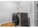 A laundry room features modern washer and dryer with shelving and wood flooring at 507 Mirramont Pl, Woodstock, GA 30189
