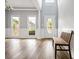 Bright living room with light gray walls, white trim, hardwood floors, and a wooden bench at 507 Mirramont Pl, Woodstock, GA 30189