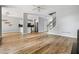 Hardwood floors connect the open living room to the modern kitchen and staircase at 507 Mirramont Pl, Woodstock, GA 30189