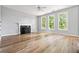 Spacious living room with hardwood floors, neutral paint, a fireplace, and large windows at 507 Mirramont Pl, Woodstock, GA 30189