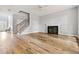 Open-concept living room showcasing hardwood floors, a staircase, and a fireplace at 507 Mirramont Pl, Woodstock, GA 30189