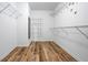 Large walk-in closet with shelving units and wood-look flooring at 507 Mirramont Pl, Woodstock, GA 30189