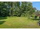 View of a spacious, grassy backyard with trees at 680 Harbor Point Ct, Lawrenceville, GA 30044