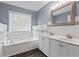 Bathroom featuring a soaking tub, double sink vanity, and a large window at 680 Harbor Point Ct, Lawrenceville, GA 30044