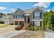 Charming two-story home features a gray exterior, brick accents, and a well-maintained front yard with colorful flowers at 680 Harbor Point Ct, Lawrenceville, GA 30044