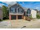 Two story home with gray siding, a brick facade, and black garage doors, offering a classic and appealing curb appeal at 680 Harbor Point Ct, Lawrenceville, GA 30044