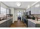 Well-equipped kitchen with stainless steel appliances, granite countertops, gray cabinets and a view to the sunroom at 680 Harbor Point Ct, Lawrenceville, GA 30044