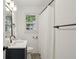 This full bathroom has patterned tile floors, a bathtub, a window, and a vanity with framed mirror at 2130 Main Nw St, Atlanta, GA 30318