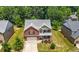 Aerial view of a two-story home with an attached garage, lush lawn, and surrounding trees at 2445 Whitehead Place Dr, Suwanee, GA 30024