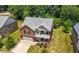 Aerial view of a two-story brick home, showcasing the well-manicured lawn, and mature trees in a quiet neighborhood at 2445 Whitehead Place Dr, Suwanee, GA 30024