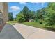 Large backyard with a concrete patio, lush lawn, mature trees, and storage shed offers outdoor enjoyment at 2445 Whitehead Place Dr, Suwanee, GA 30024
