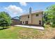 View of the house backyard featuring a grass lawn, a concrete patio and a two-story house at 2445 Whitehead Place Dr, Suwanee, GA 30024