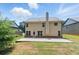 Exterior of home features a large backyard with a concrete patio and lush green grass at 2445 Whitehead Place Dr, Suwanee, GA 30024