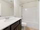 Bathroom with a single sink vanity, toilet, and a shower-tub combination with white tile surround at 2445 Whitehead Place Dr, Suwanee, GA 30024