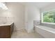 Well-lit bathroom with tub, tile flooring, and neutral decor, ready for a soothing experience at 2445 Whitehead Place Dr, Suwanee, GA 30024