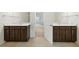 Double vanity with dark wood cabinets and light countertops in a bright, clean bathroom at 2445 Whitehead Place Dr, Suwanee, GA 30024